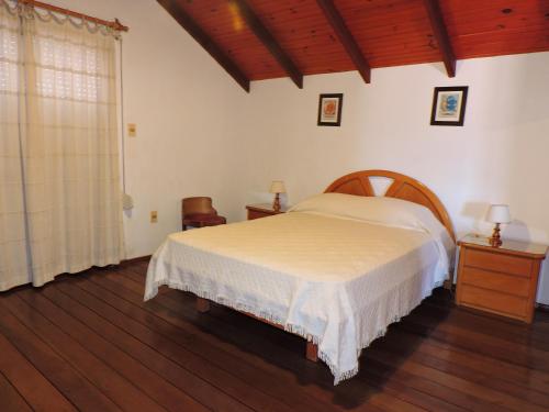 1 dormitorio con 1 cama y suelo de madera en PECO Punta del Diablo, en Punta del Diablo