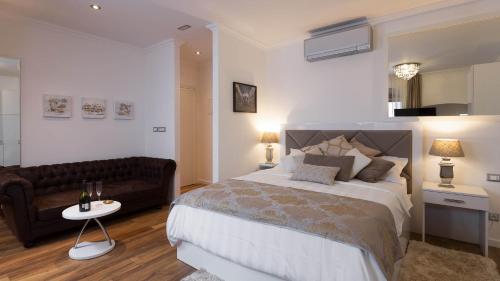 a bedroom with a large bed and a couch at Guest House Imperial in Split