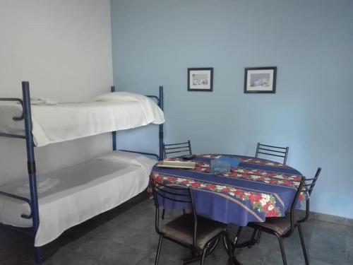 a room with two bunk beds with a table and chairs at Cabañas Los Girasoles in Gualeguaychú