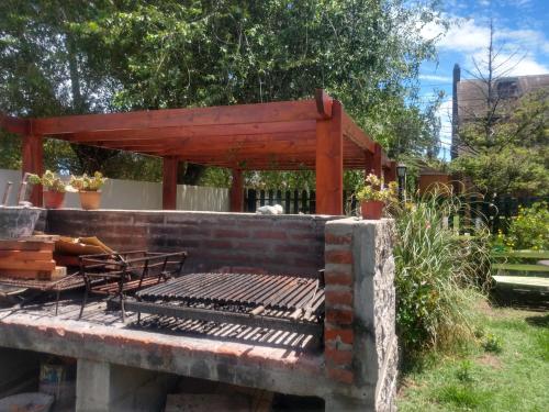 a fire pit with a bench on a brick wall at Zahra Depto in Villa Gesell