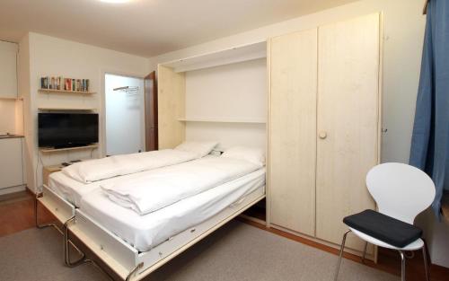 サンモリッツにあるAllod Bad 111の小さなベッドルーム(ベッド1台、椅子付)