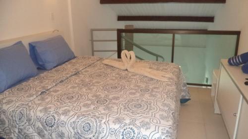 Un dormitorio con una cama con un edredón azul y blanco. en Laguna Beach Flat, en Porto de Galinhas