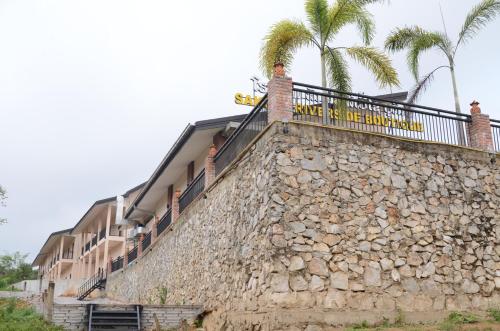 a building with a stone wall with a sign on it at Saksiri Riverside Boutique Hotel in Vang Vieng