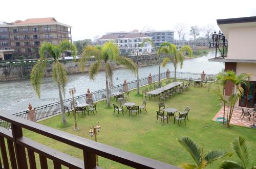 a balcony with tables and chairs next to a river at Saksiri Riverside Boutique Hotel in Vang Vieng