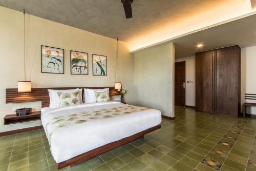 a bedroom with a large bed in a room at Penh House Hotel in Phnom Penh