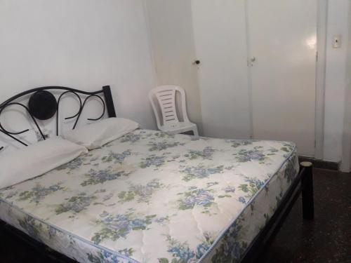 1 dormitorio con 1 cama con colcha de flores en Casa Vacacional Los Nietos en Quequén