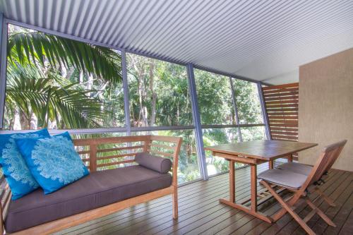 a patio area with a couch, chairs and a table at Angourie Resort in Yamba