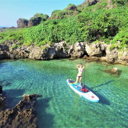 a person on a paddle board in the water at MoMo B&B in Hengchun