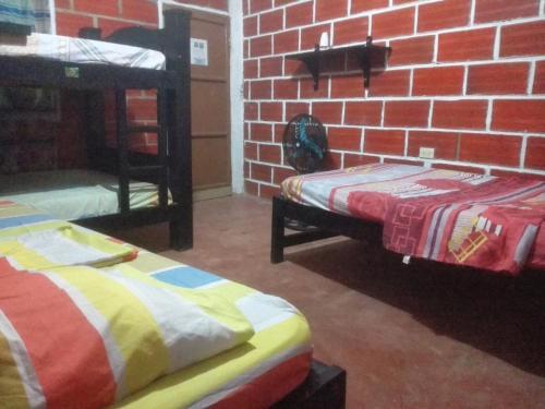a room with two beds and a brick wall at Rancho Mar in Rincón