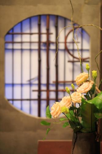 a vase with flowers in front of a mirror at TAMACO in Kanazawa in Kanazawa