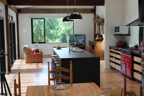 a kitchen with a black counter and a dining room at Korepo Lodge @ Ruby Bay in Nelson