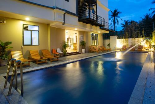 a swimming pool in front of a house at Nesta Hotel Phu Quoc in Phu Quoc