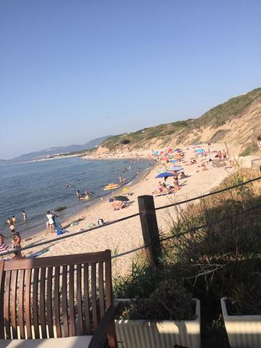 a beach with a bench and people on the beach at La Medusa in La Ciaccia