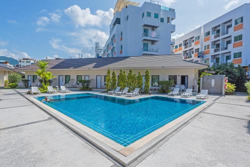 a swimming pool in front of a building at The Natural Resort in Patong Beach