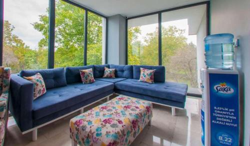 روم روم موتيل في صبنجة: أريكة زرقاء في غرفة بها نوافذ