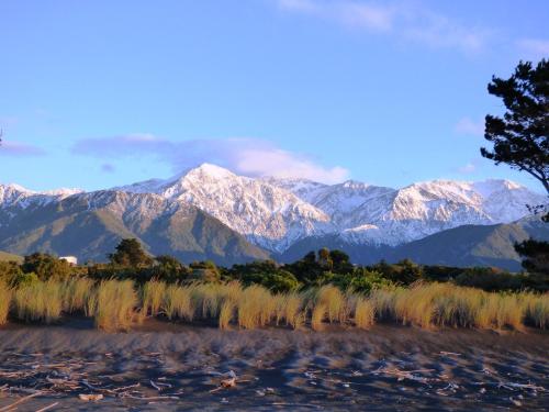 a mountain range with snow capped mountains in the background at Hapuku Carriages Kaikōura in Kaikoura