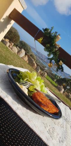 een bord met wortelen en sla op tafel bij Villa Sprafundu in La Maddalena