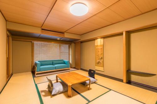 a living room with a blue couch and a table at Honjin in Izunokuni