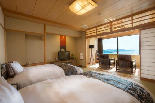 a hotel room with two beds and a television at Jukaitei in Kyotango
