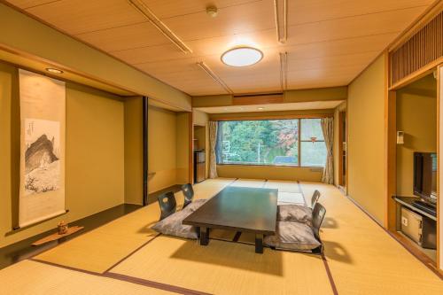 a living room with a table and chairs at Honjin in Izunokuni
