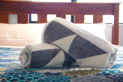 a person with their feet in a blanket on a bed at Hamilton East Homestay in Hamilton
