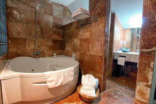 
a bath tub sitting next to a toilet in a bathroom at Hotel Spa Milagros Golf in Mogro

