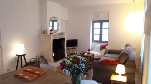 a living room with a couch and a fireplace at 269 Bel Ebat in Le Bois-Plage-en-Ré