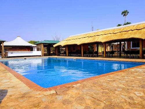 a large blue swimming pool in front of a building at Kampi Ya Boma Kolwezi in Kolwezi