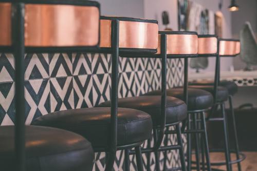 a row of black bar stools against a wall at Latitude 15 Degrees in Lusaka