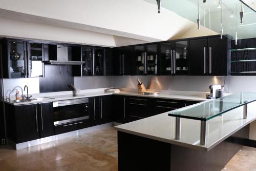 a kitchen with black cabinets and a glass counter top at Heaven's Window in Hermanus