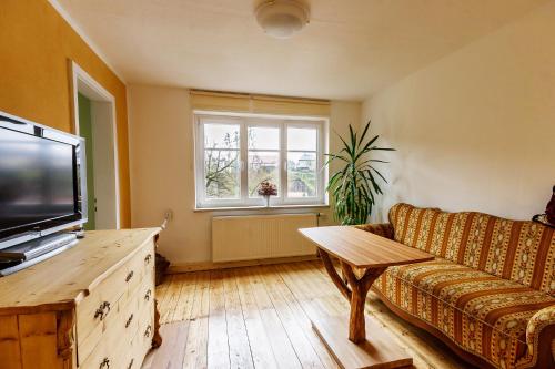 a living room with a couch and a television at Schloßblick in Lohmen