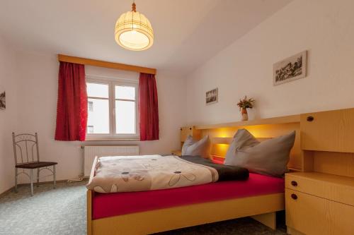 a bedroom with a bed and a window and a chandelier at Schloßblick in Lohmen