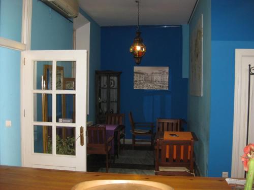 a living room filled with furniture and a blue door at Las Acacias Hostal Restaurante in Málaga
