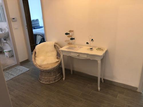 a small white table and a chair in a room at Casa Bianca Laigueglia in Laigueglia