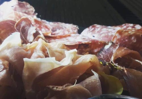 a pile of bacon and meat on a table at Hôtel Du Midi in Thônes