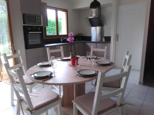 a kitchen with a wooden table with chairs and a dining room at Gite Du Moulin Du Vivier in Seigy