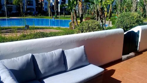 a couch sitting on a balcony with a view of a pool at Luxury Flat Marina Agadir in Agadir