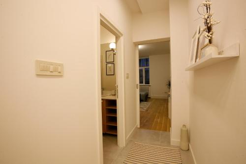 een hal met een deur naar een badkamer met een wastafel bij BestStay Apartment No 9 Pedestrian zone in Belgrado