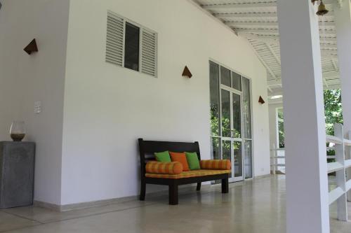 a chair in a room with a white wall at Beach Grove Villas in Unawatuna