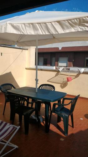 a picnic table with two chairs and an umbrella at Beach House in Torvaianica