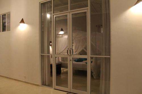 a white cabinet with glass doors in a room at Beach Grove Villas in Unawatuna
