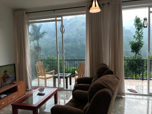 a living room with a couch and a large window at Country Homes in Ella