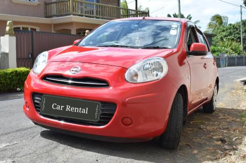 a small red car rental parked on a street at Seaview Kite Studio - La Gaulette in La Gaulette