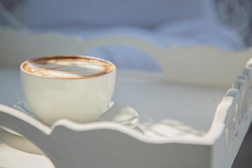 a cup of coffee sitting on a table at Seeplaas Guesthouse in Groot Brak Rivier