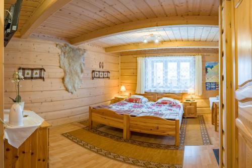 sypialnia z łóżkiem w drewnianym pokoju w obiekcie Stare Krzeptówki w Zakopanem