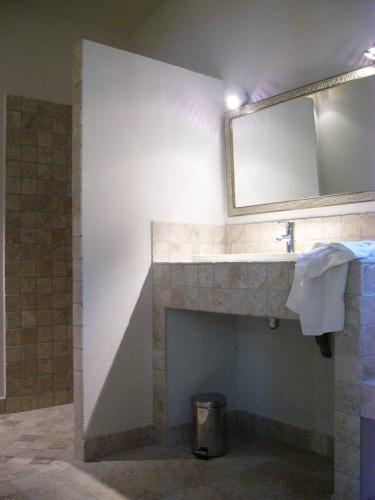 La salle de bains est pourvue d'une cheminée avec un miroir et un lavabo. dans l'établissement Mas Boudeissoun - Grain de Muscat - Baignade à 600 m, à Mormoiron