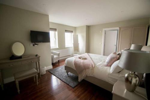 1 dormitorio con cama, escritorio y espejo en West Haven House en Doolin