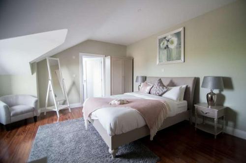 a bedroom with a large bed and a chair at West Haven House in Doolin