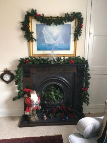 a fireplace with a christmasreath on top of it at Pomegranate in Coleford