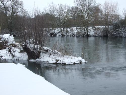 a river with snow on the banks and trees at Chambres d'hotes du Port Gautier in Vouvray-sur-Loir